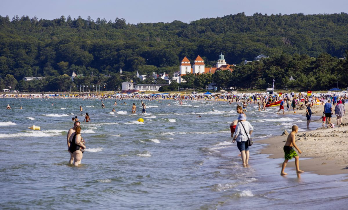 Badegäste am Strand und im Wasser im Urlaub an der Ostsee