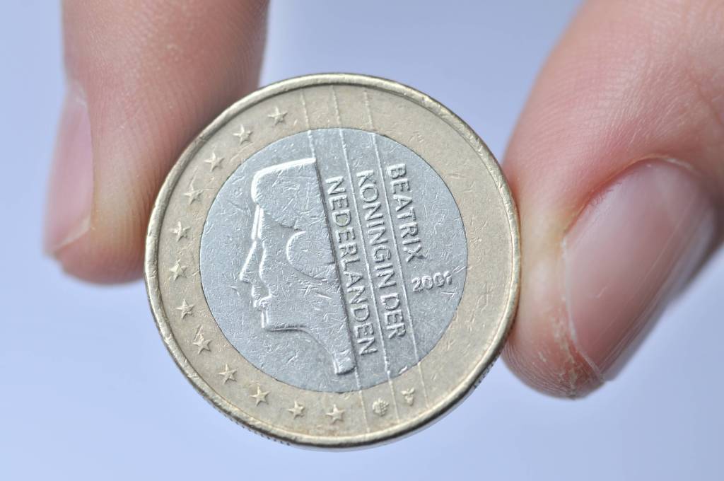 Ein Mensch hält eine 1-Euro-Münze mit dem Motiv "Beatrix, Königin der Niederlande".