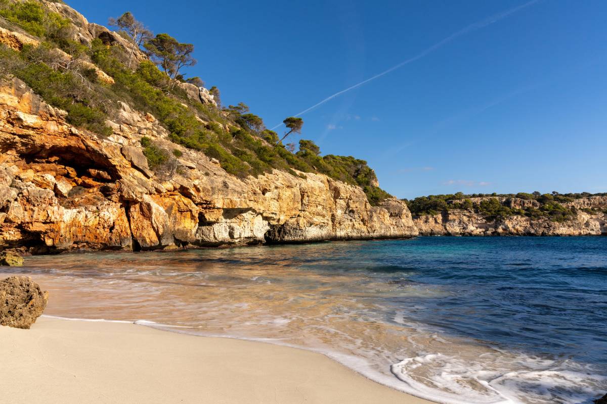 Sandstrand mit Felsen und Meer.