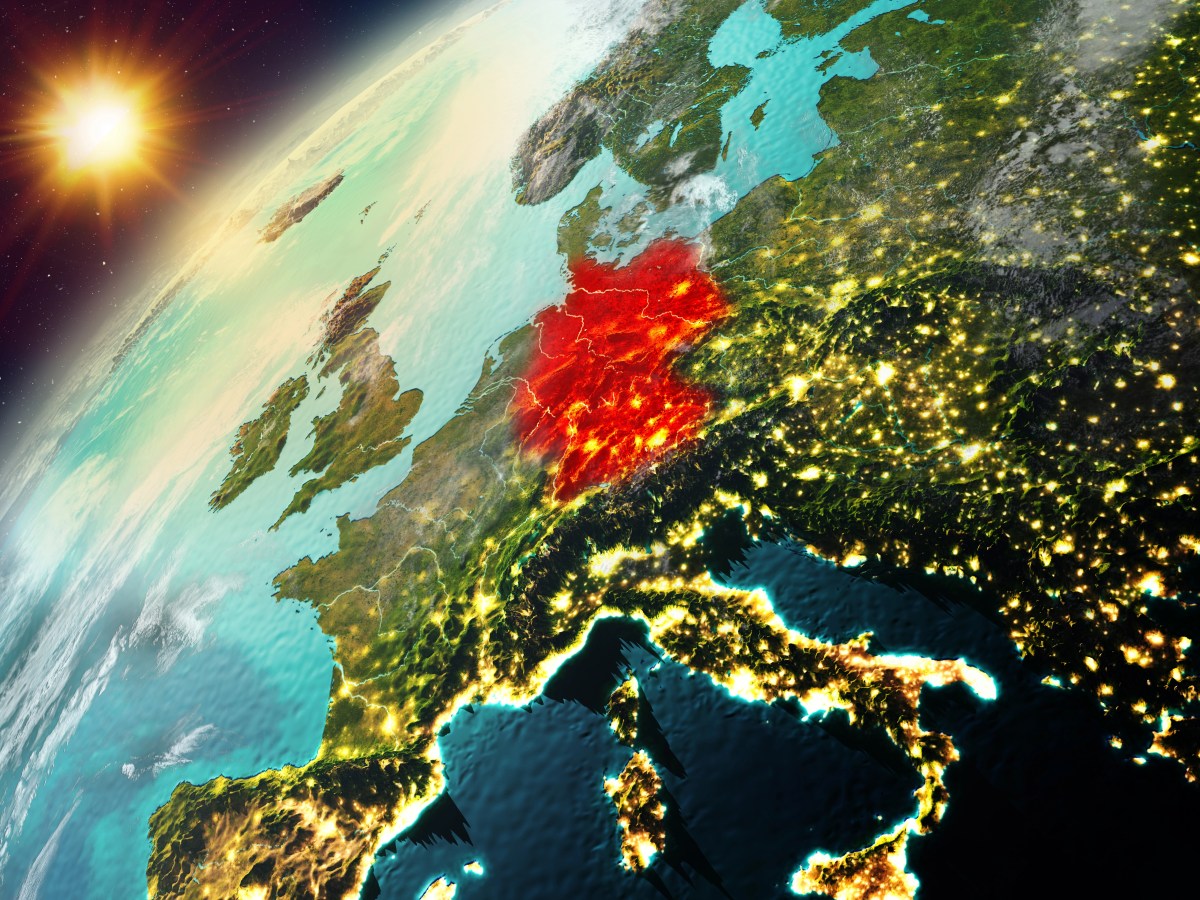Ein Blick aus dem Orbit auf die Erde hinter der die Sonne aufsteigt. Deutschland ist mit roter Farbe markiert.